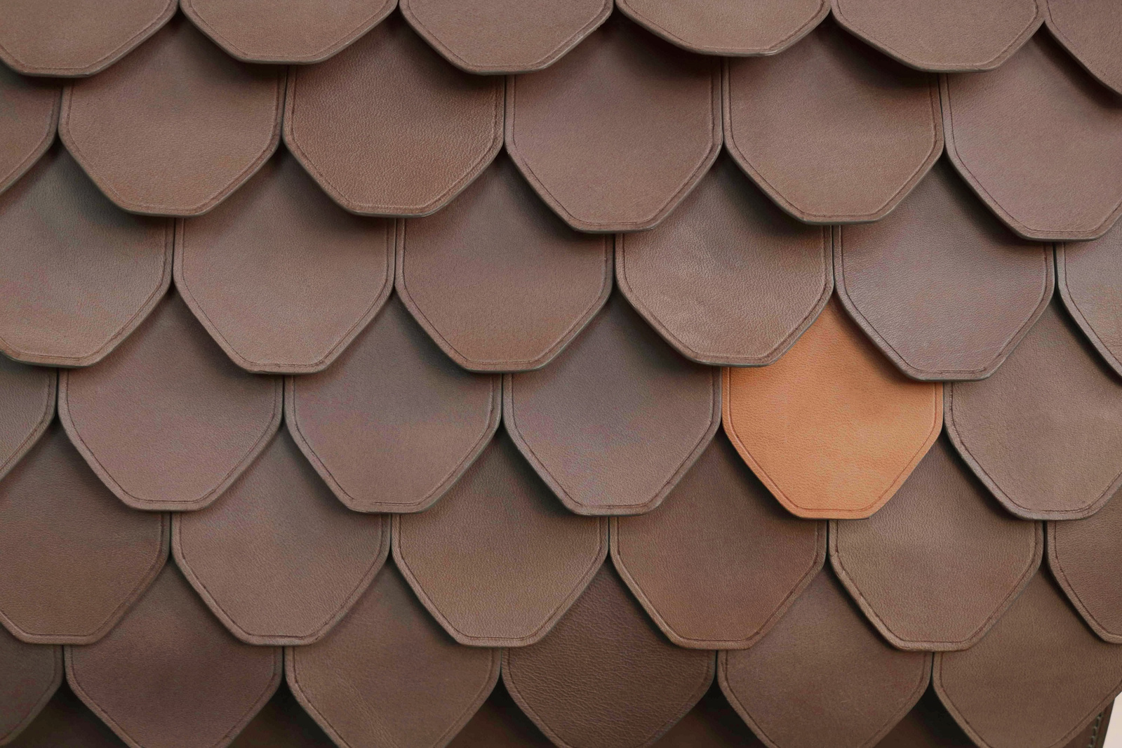 Les écailles sont en cuir à tannage végétal taupe et naturel.