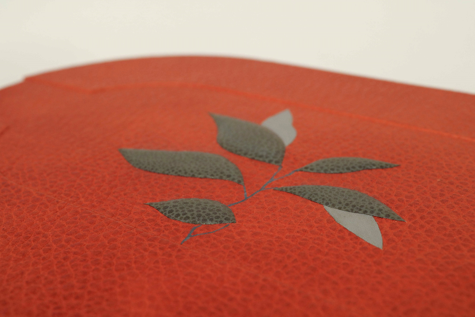 Les feuilles de théier sur le couvercle sont réalisées avec les techniques d'incrustation à niveau et de mosaïque bombée.