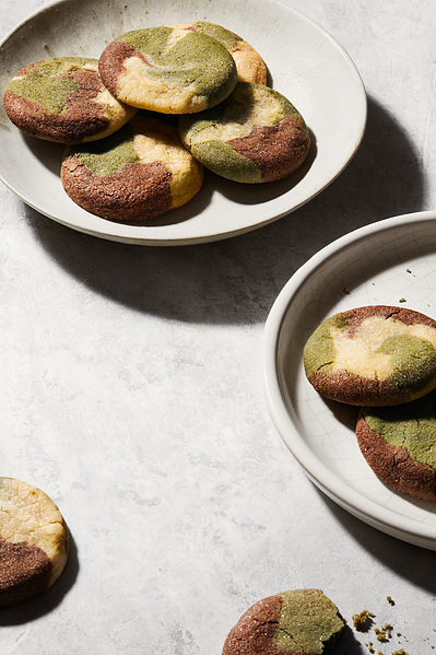 Matcha cookies on white plates on light background, sitting aesthetically styled by a food stylist and photographed by a professional food photographer