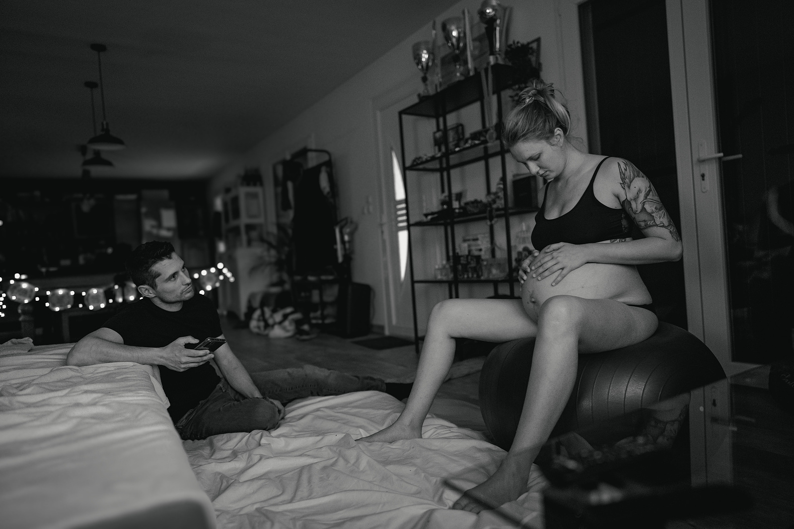 Accouchement à la maison, le père compte le temps entre les contractions en attendant l'arrivée de la doula