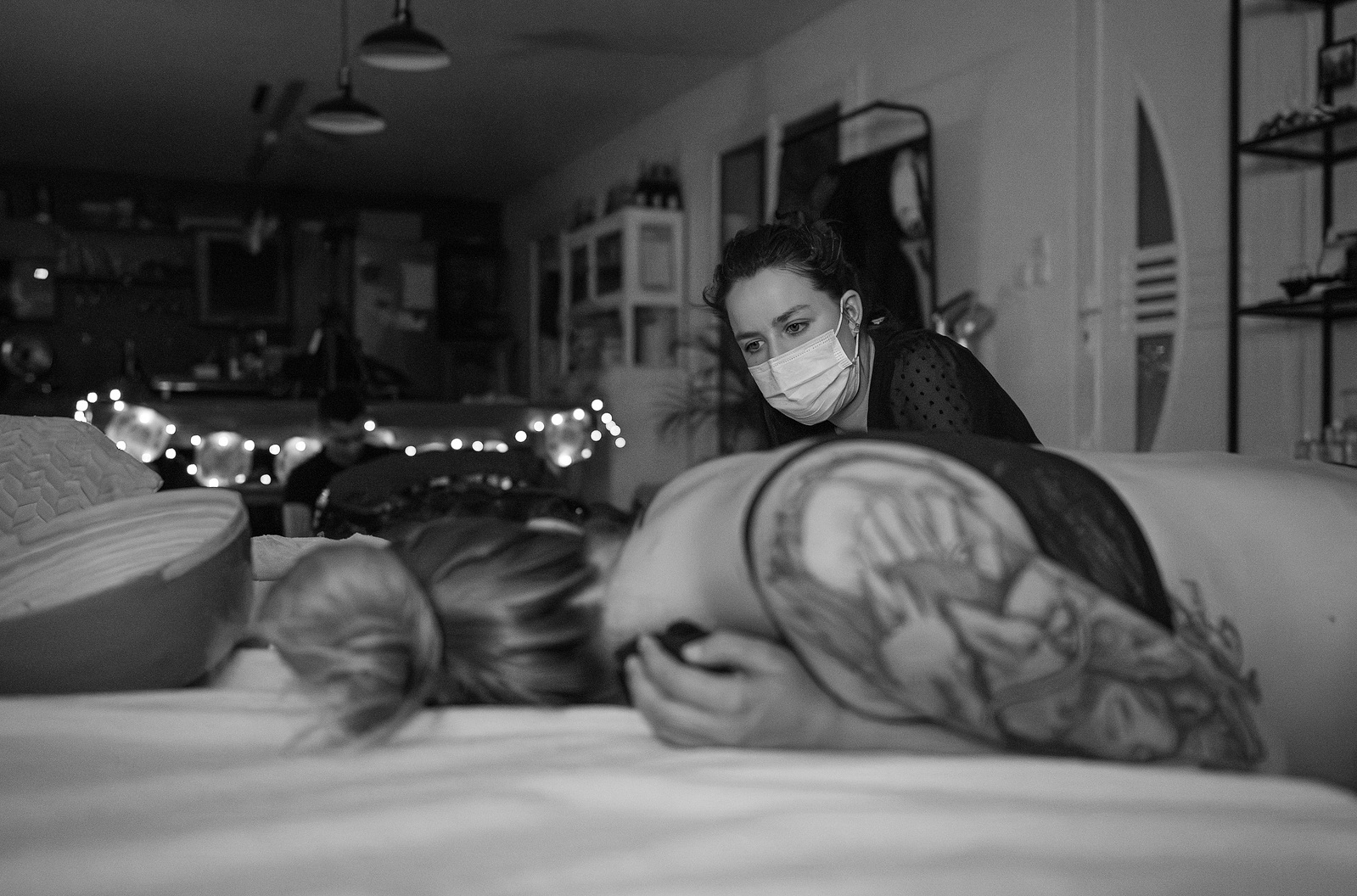 Une jeune maman avec des tatouages a ses première contractions, elle accouche à domicile, la sage-femme l'assiste.