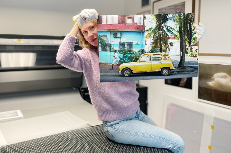 Maria Schiffer holding up a picture she shot in Madagascar of a yellow R4.