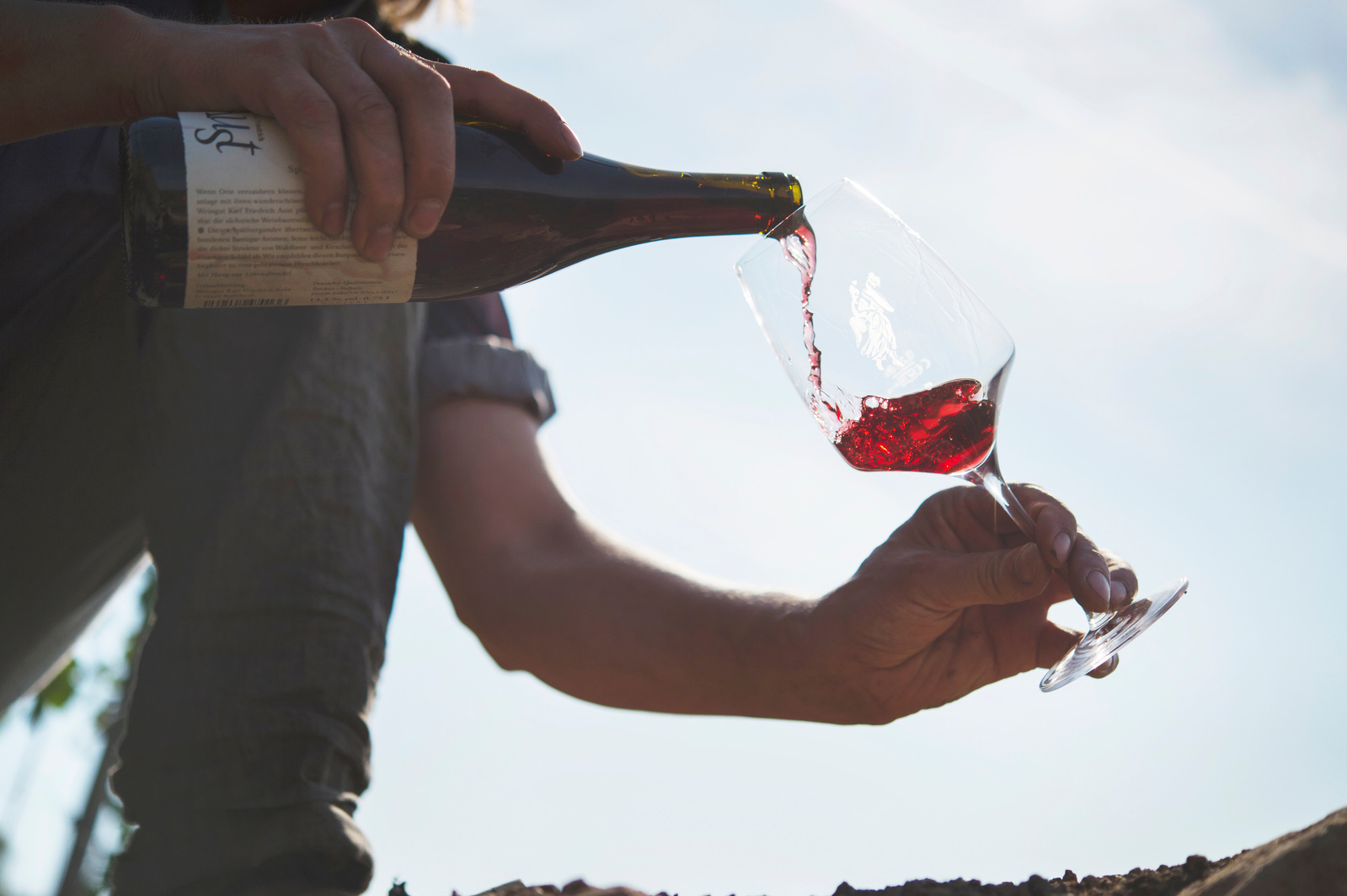 Pouring a red glass of wine in a German vineyard. 
