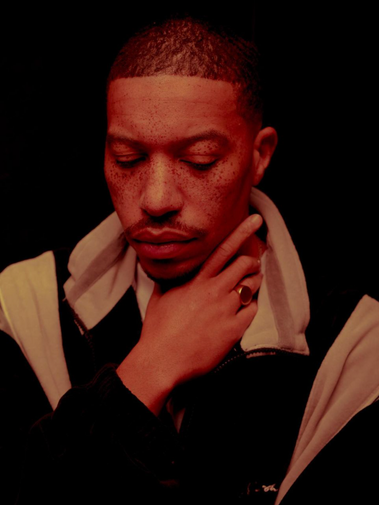 Stylized editorial portrait of Sean Brown wearing a black-and-tan coat, part of Bully Magazine’s Image Issue. Creative production by Rashaad Denzel.
