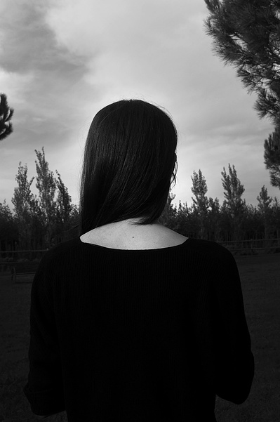Retrato de nuca de mujer sonriente con paisaje natural por detrás  David Salcedo
