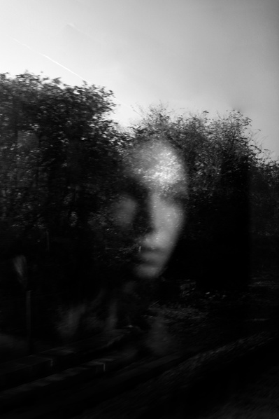 Reflejo de mujer triste en un cristal con arboles desenfocados David Salcedo