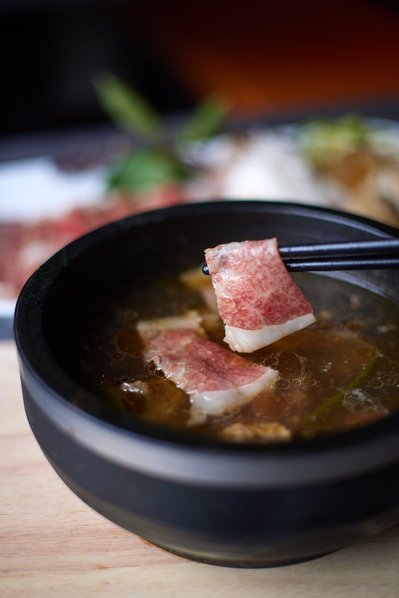 NYC-based food photographer shooting artisan soup in studio for cookbook.