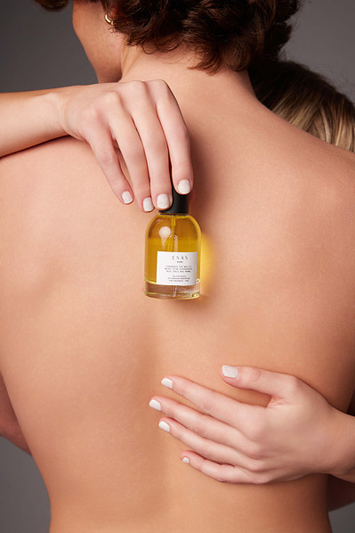 In-studio fragrance campaign featuring models holding luxury perfume bottles with elegant poses.