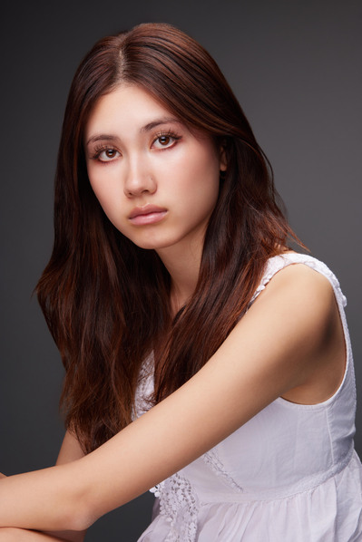 Actor headshot with a soft studio backdrop, ideal for professional branding and auditions.