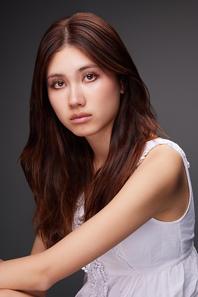 Actor headshot with a soft studio backdrop, ideal for professional branding and auditions.