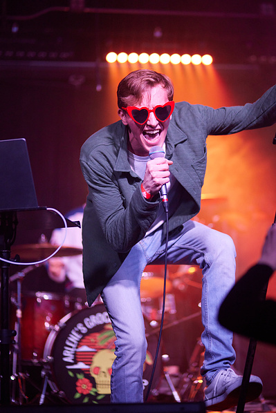Dramatic stage lighting enhancing rock music photography.