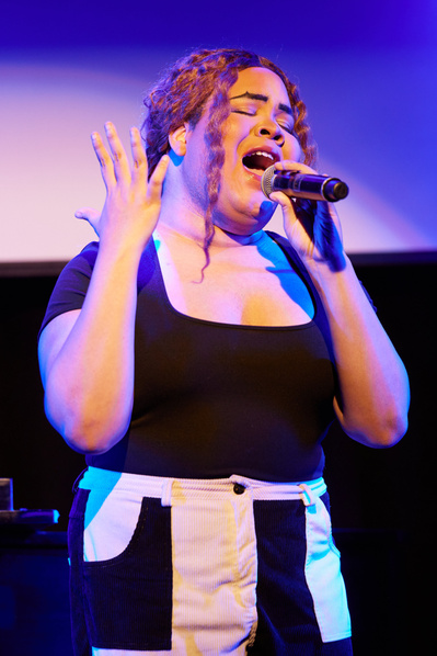 Close-ups of performers emoting on stage in Broadway theater.