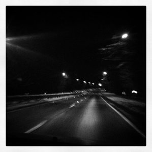 Black and white of the asphalt of a highway, with painted lines