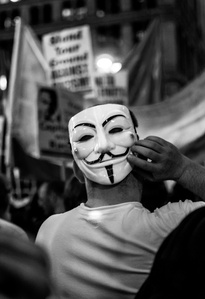 Black and white Protestor wearing a Guy Fawkes mask during an Occupy Wall Street protest in midtown manhattan