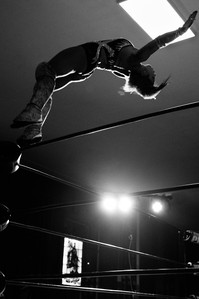 A black and white photo of Lady Frost in the middle of a Moonsault during a WrestlePro event in Brooklyn NY.