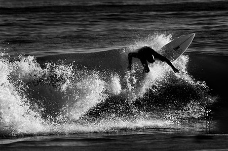 Surfer going vertical while riding a wave in Rockaway Beach Queens, NY.