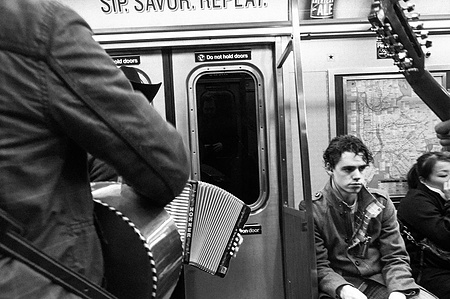 Passenger not amused by a two Mexican busker's performance with the accordion and guitar. New York City Subway.