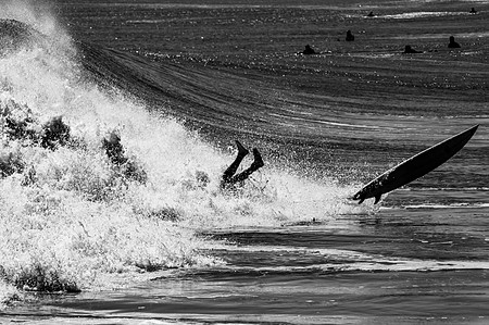 Surfer wiping out in Rockaway Beach Queens, NY as other surfers watch from a distance