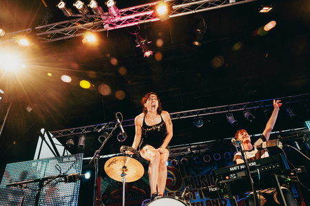 Kim Schifino from Matt and Kim gesticulating to the crowd on top of her drum set during the 2010 Mermaid Parade