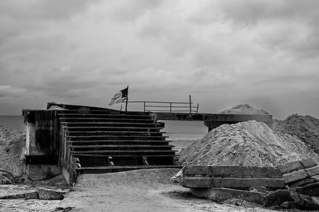 American flag waving from a boardwalk destroyed by Hurricane Sandy in Rockaway Beach Queens, NY.