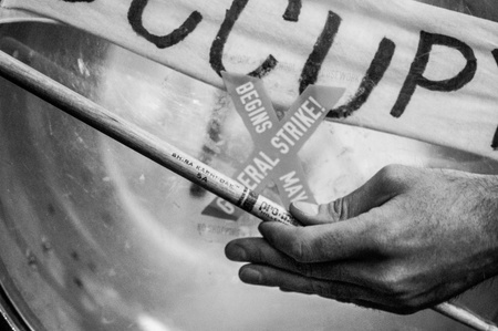 A black and white photo of a drummer&#x27;s hand during a march for Occupy Wall Street