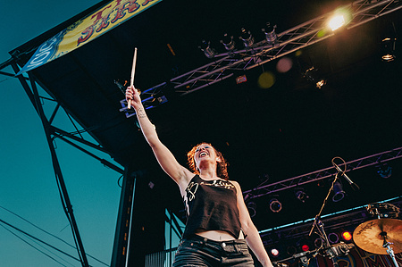 Kim Schifino of Matt and Kim holding up a drum stick while performing in the 2010 Siren Festival