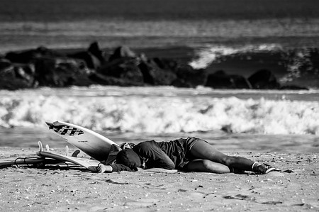 Surfer girl enjoying the sun on the sand in Rockaway Beach Queens, NY.