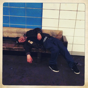 A person sleeping on a bench on the Bay Ridge Avenue station in Brooklyn