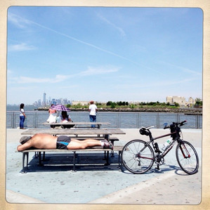 Old man sunbathing on a park bench at Owl&#x27;s Head Pier in Bay Ridge, Brooklym