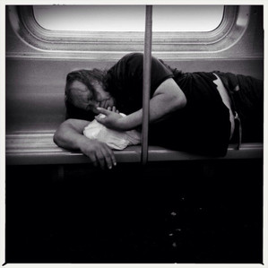 Homeless man sniffing his fingers on the New York City subway