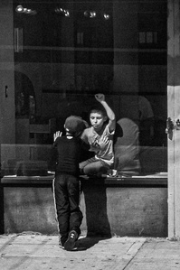 two boys playing on the opposite sides of a window in Bensonhurst Brooklyn