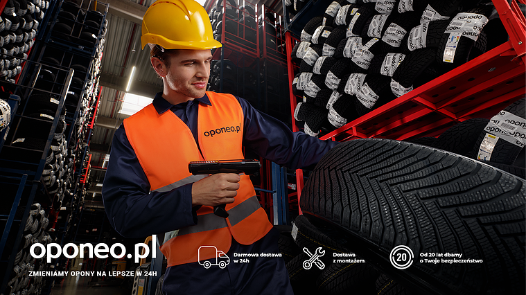 Campaign still showcasing oponeo.pl employee in action, scanning a tire's label. On-set lifestyle shot blending commercial photography techniques with storytelling-driven composition