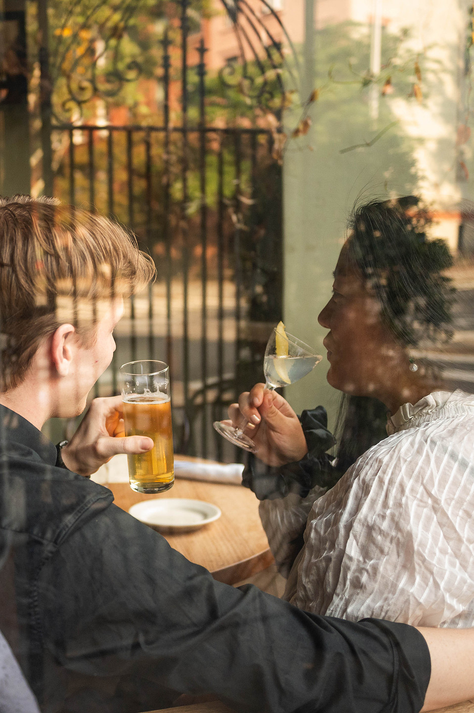 Candid engagement photo of couple sipping drinks in a Brooklyn restaurant