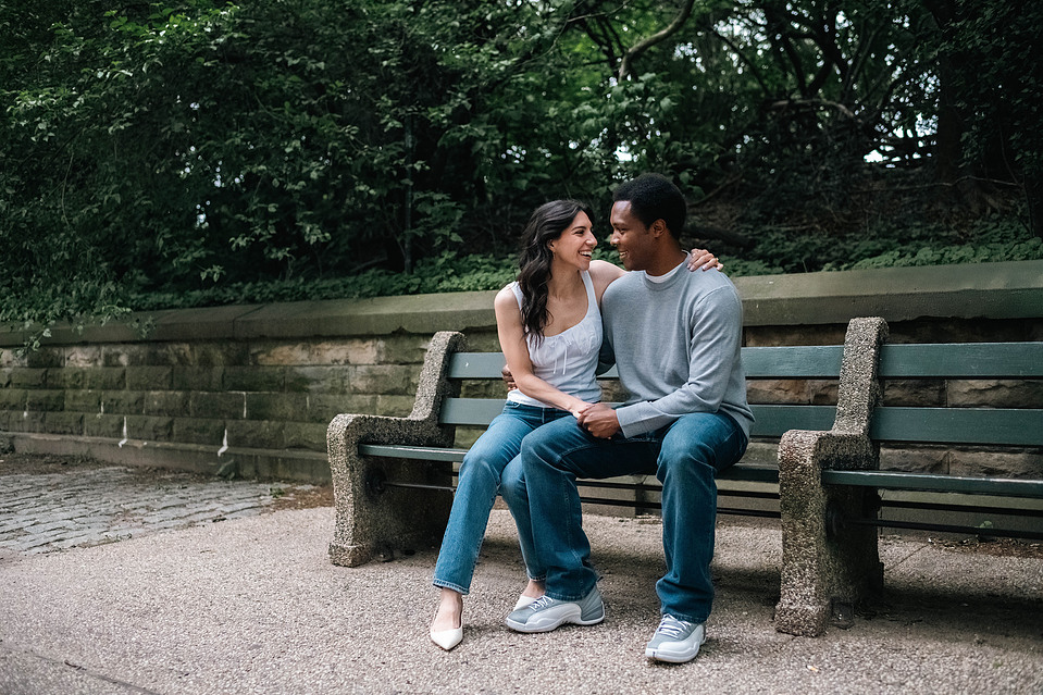 Engaged couple sitting on a bench in Prospect Park during a Brooklyn engagement session