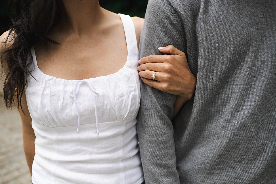 Engaged couple walking hand-in-hand under trees in Prospect Park during a Brooklyn engagement session