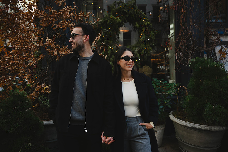 Engaged poses in front of a restaurant in SoHo, New York City