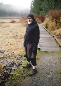 A man stops on his walk amidst the fog.
