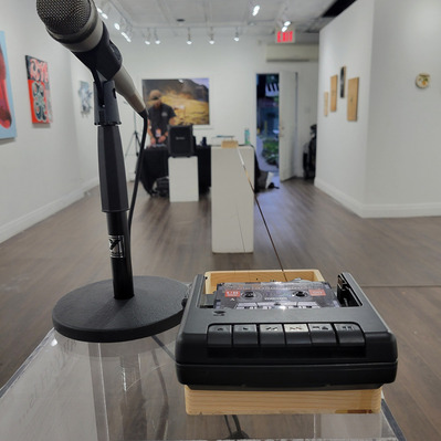 The Recording station with a tape player and microphone as a depth shot of the tape loop moving deeper into the room.