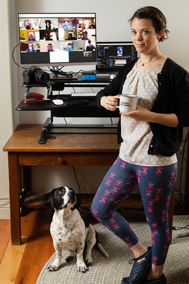 Self portrait of photographer Stephanie Stocking in front of a computer working area with her dog Petey