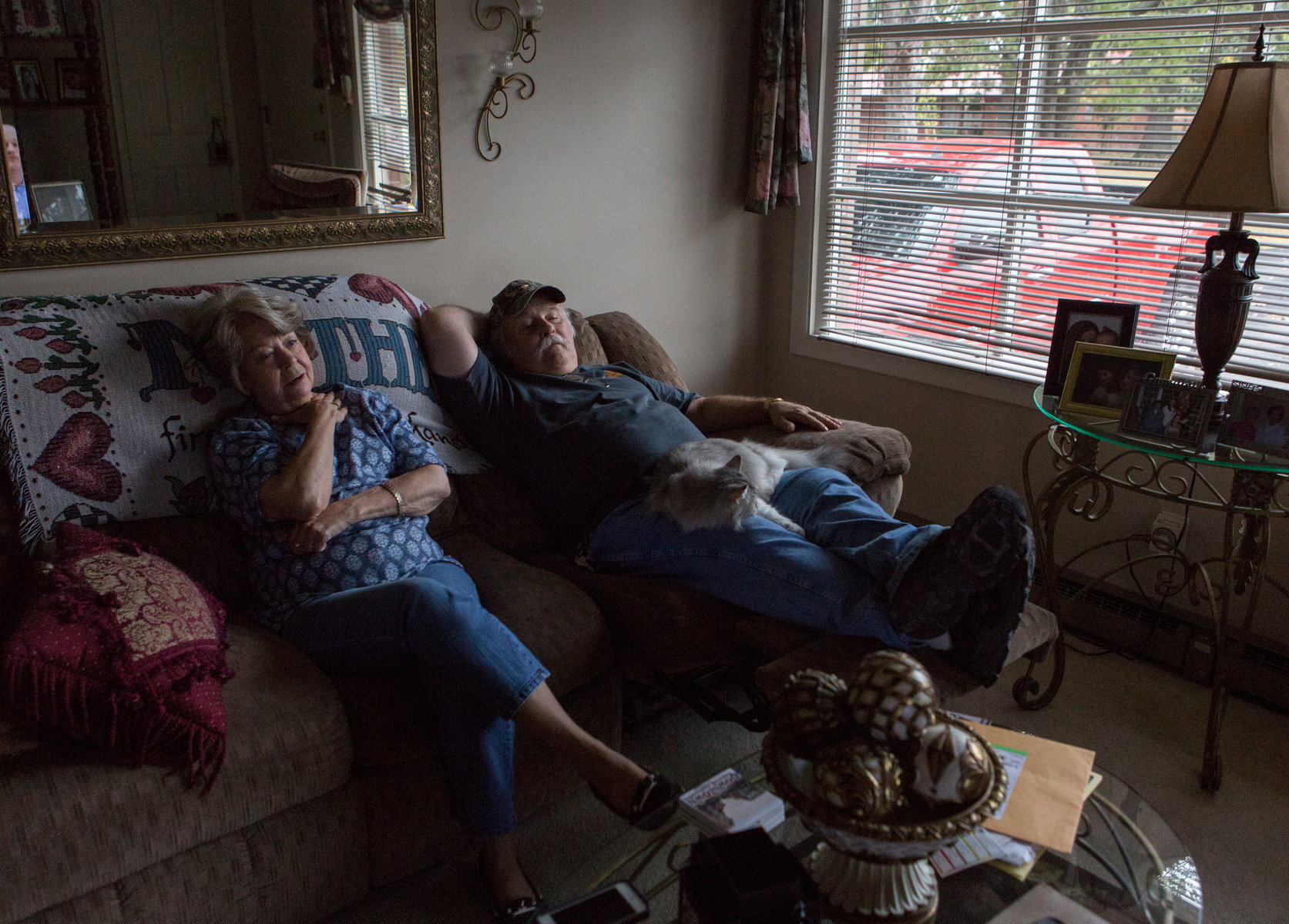 After a long work day, Howard and JoAnne relax on the couch and watch television with their cat, Sassy.