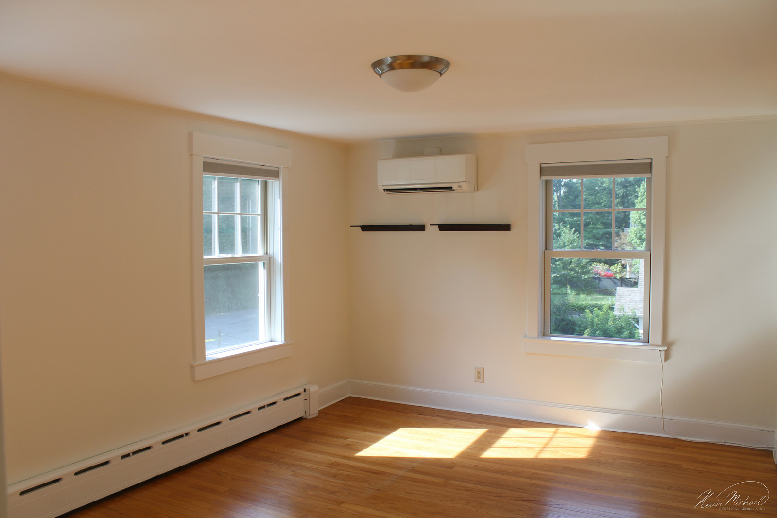 Real Estate Photography, in Westchester County, New York by Vermont-based Artist & Photographer, Kevin Michael Smith. photo of bedroom with two windows and natural light, with hardwood floors.
Rutland Photographer.
