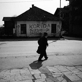 Photograph of the city center of Bratunac with Srebrenica sign in the background.