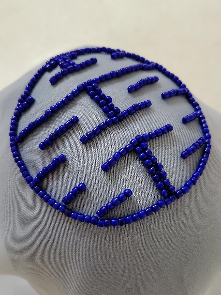 Beaded pattern of 囍 (double happiness) on the top of the veil