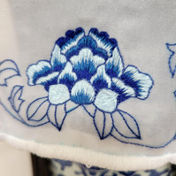detail photo of a 3-toned embroidered blue peony