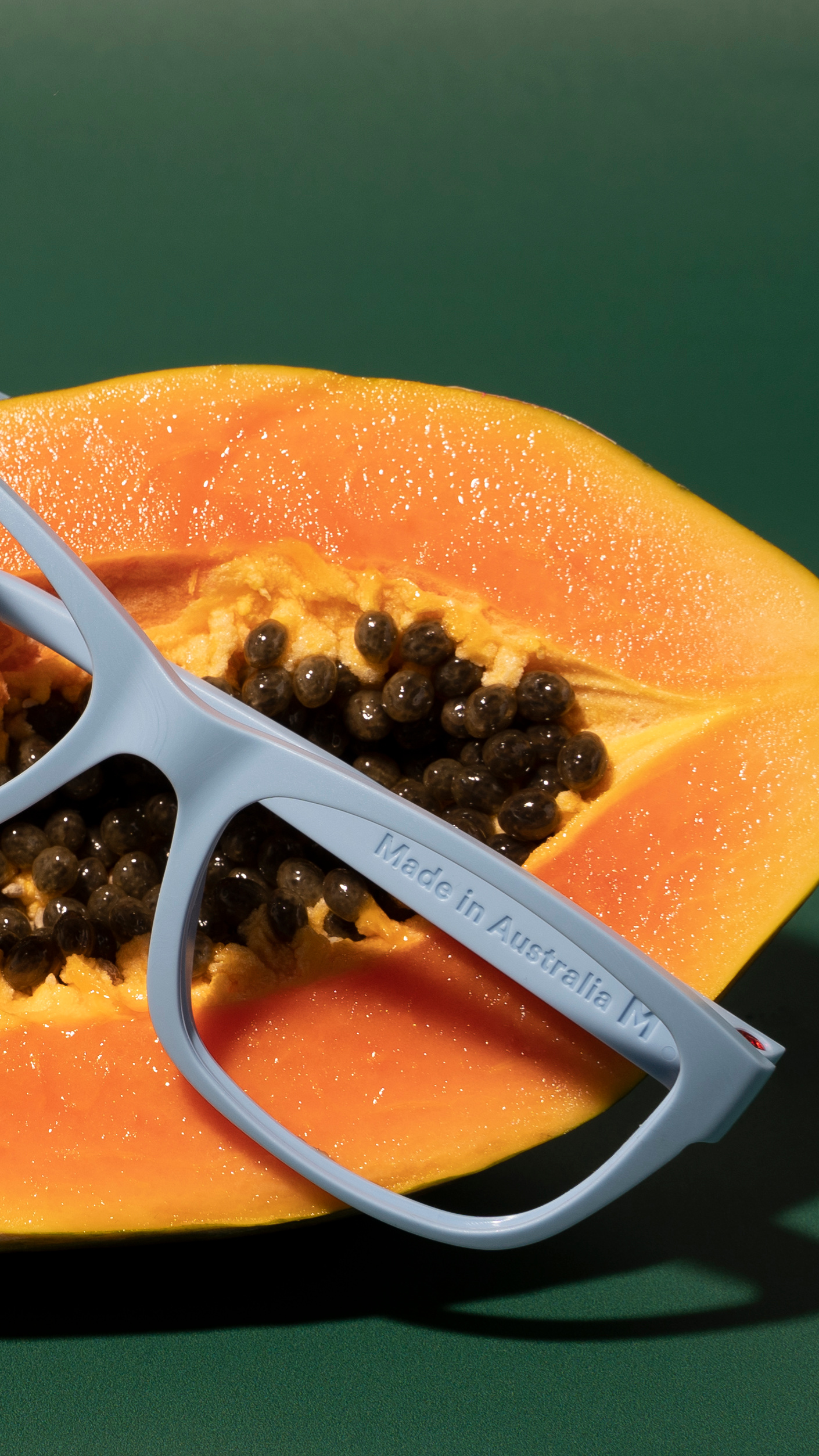 a blue glasses frame on top of an orange fruit