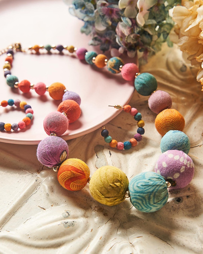 big colourful beaded necklace lying on a white surface