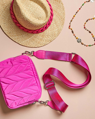 pink bag and a summer hat lying on a pink background