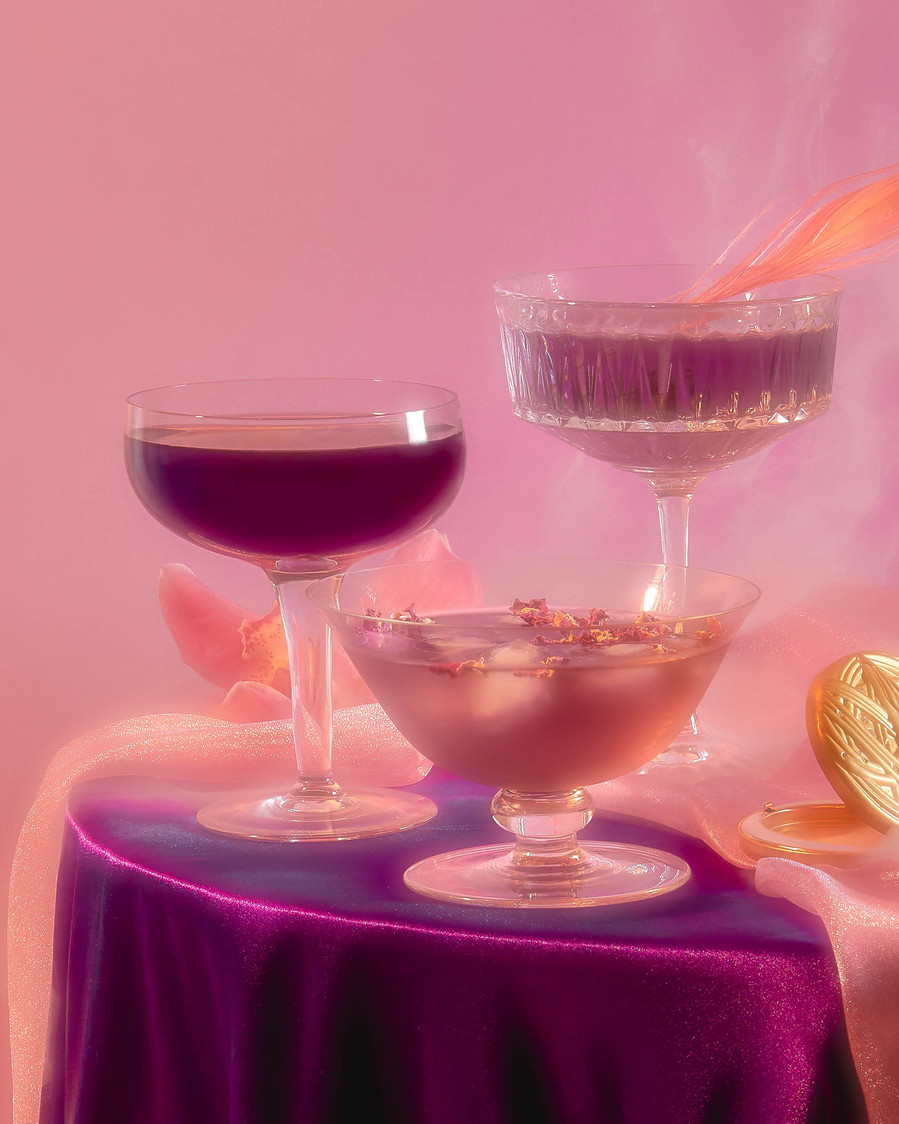 three purple drinks with a smoke coming behind them