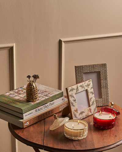 a stack of books and photo frames on a wooden table