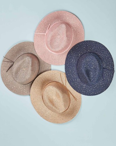 four summer hats lying on a blue background